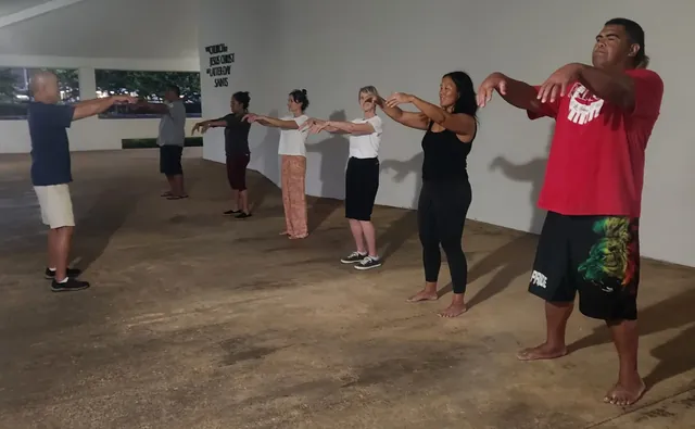 Community members standing in a line and practicing Tai Chi at Lāʻie Front Chapel.