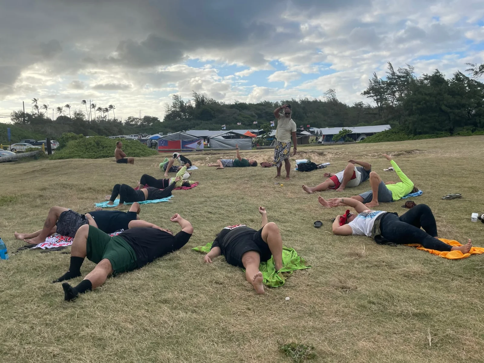 Community members participating in a tension-release session at Hukilau Beach in Lāʻie.